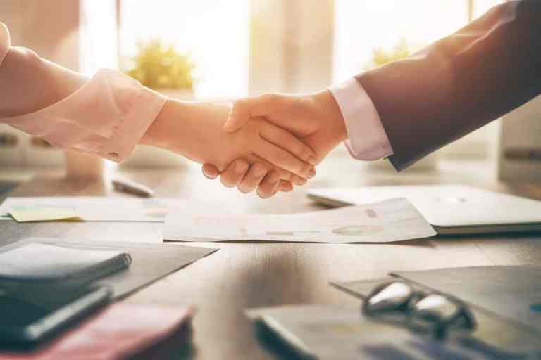 A closeup image of a handshake. This article is about ways to say "nice to meet you" in Spanish
